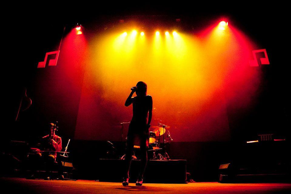Singer performing on stage with lights