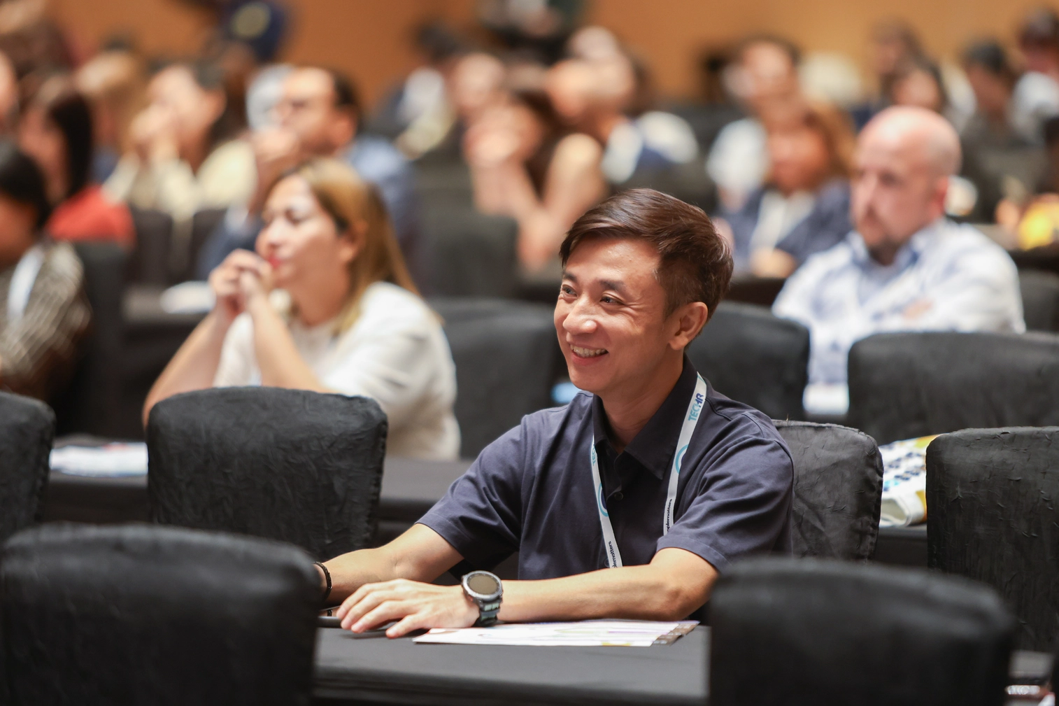 Smiling attendee engaged at conference session